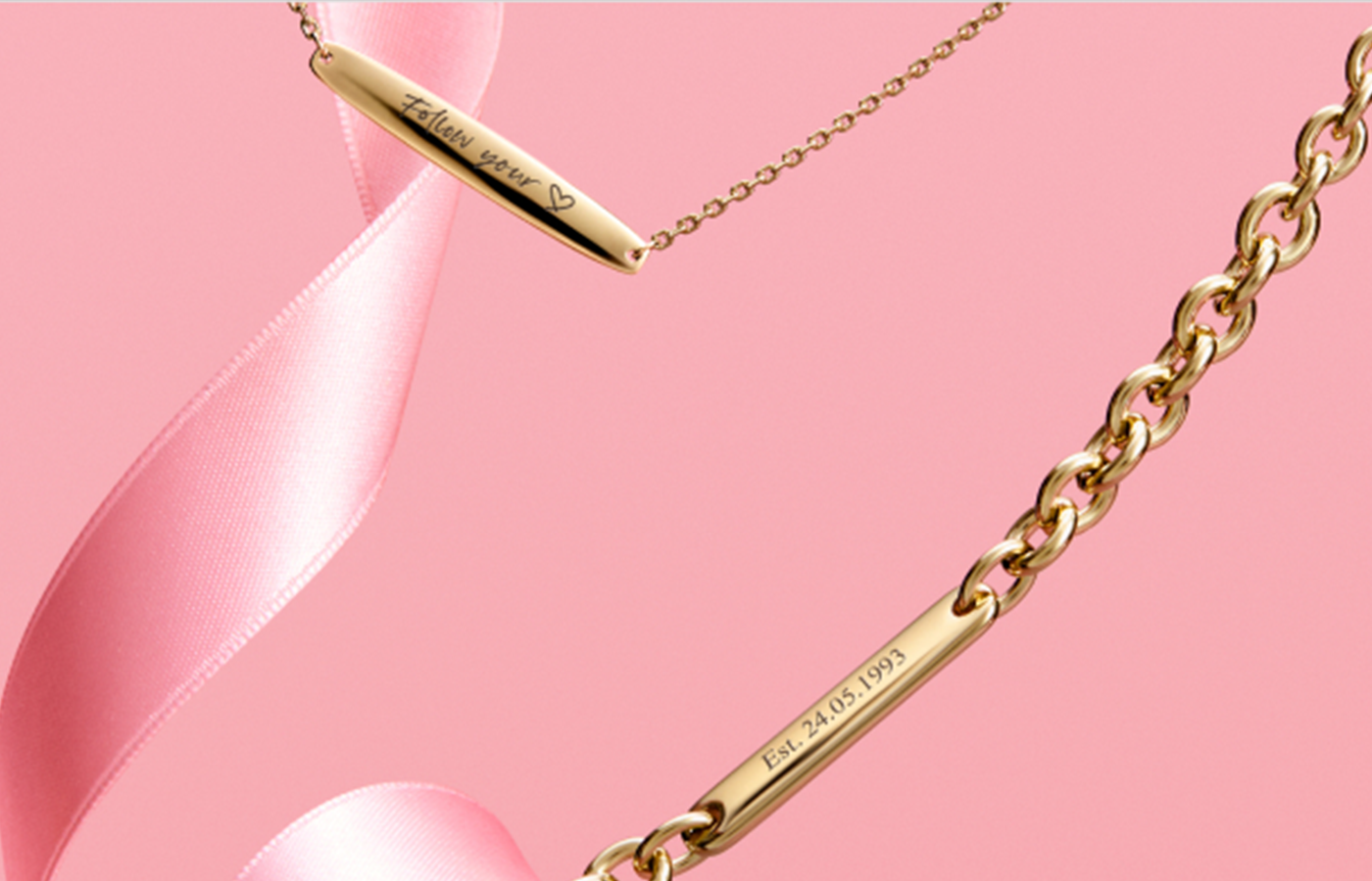 Close-up of Pandora engravable jewelry collection featuring gold bar necklaces and bracelets with personalized engravings like “Follow your ♥” and “Est. 24.05.1993” — styled with a soft pink ribbon for meaningful, custom gifting.