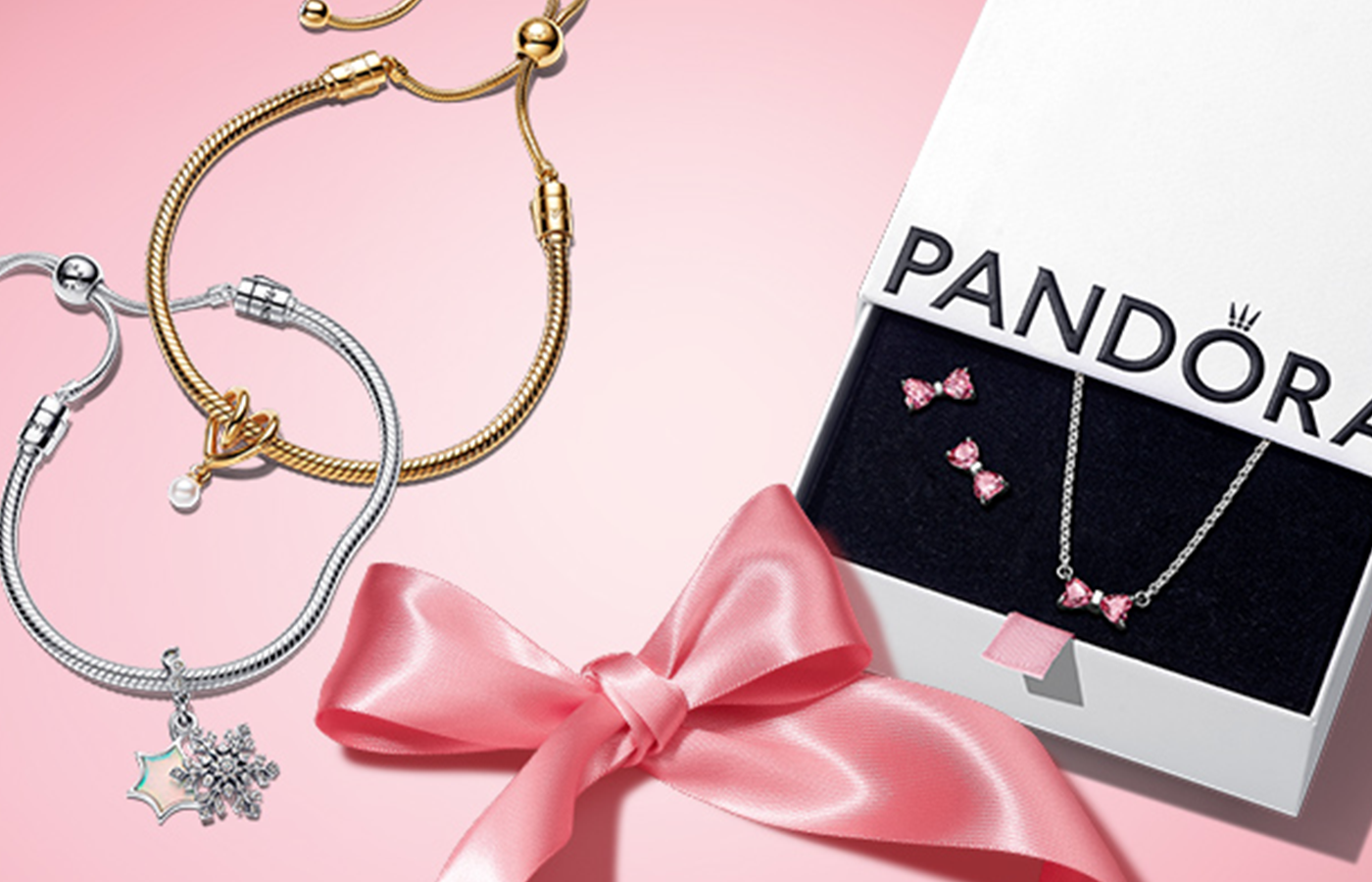 Pandora gift sets featuring silver and gold bracelets with charms and a pink bow jewelry gift box containing a matching pink bow necklace and stud earrings.